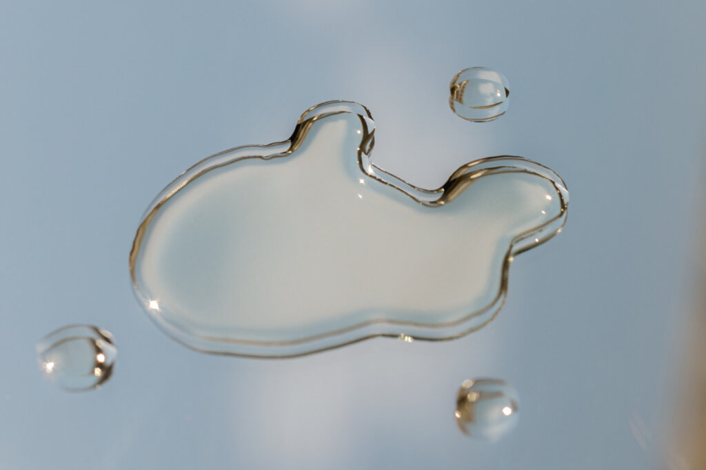 Close-up of glass-like liquid droplets on a light background, representing a concentrated active ingredient